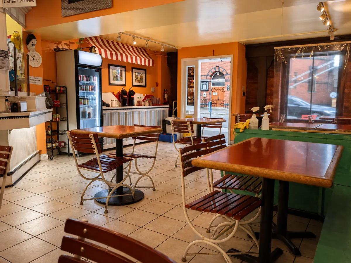 Café tables, colourful walls and the front window inside the deli