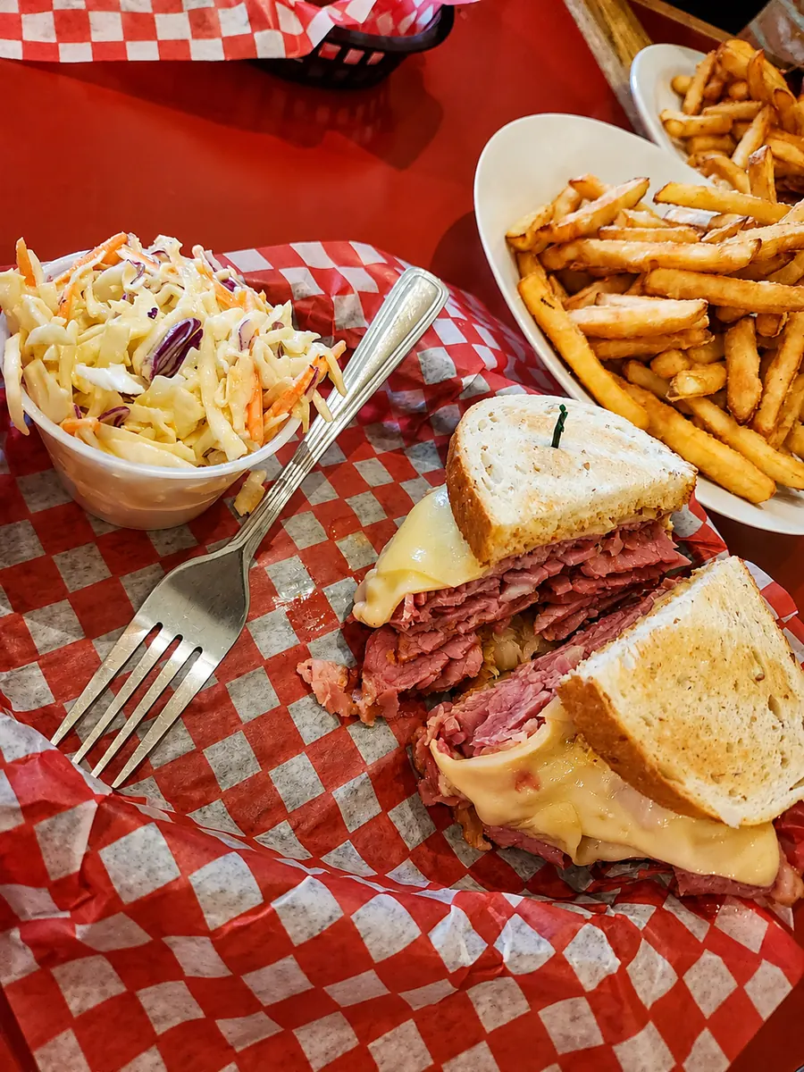 Smoked meat and cheese sandwich on checked deli paper