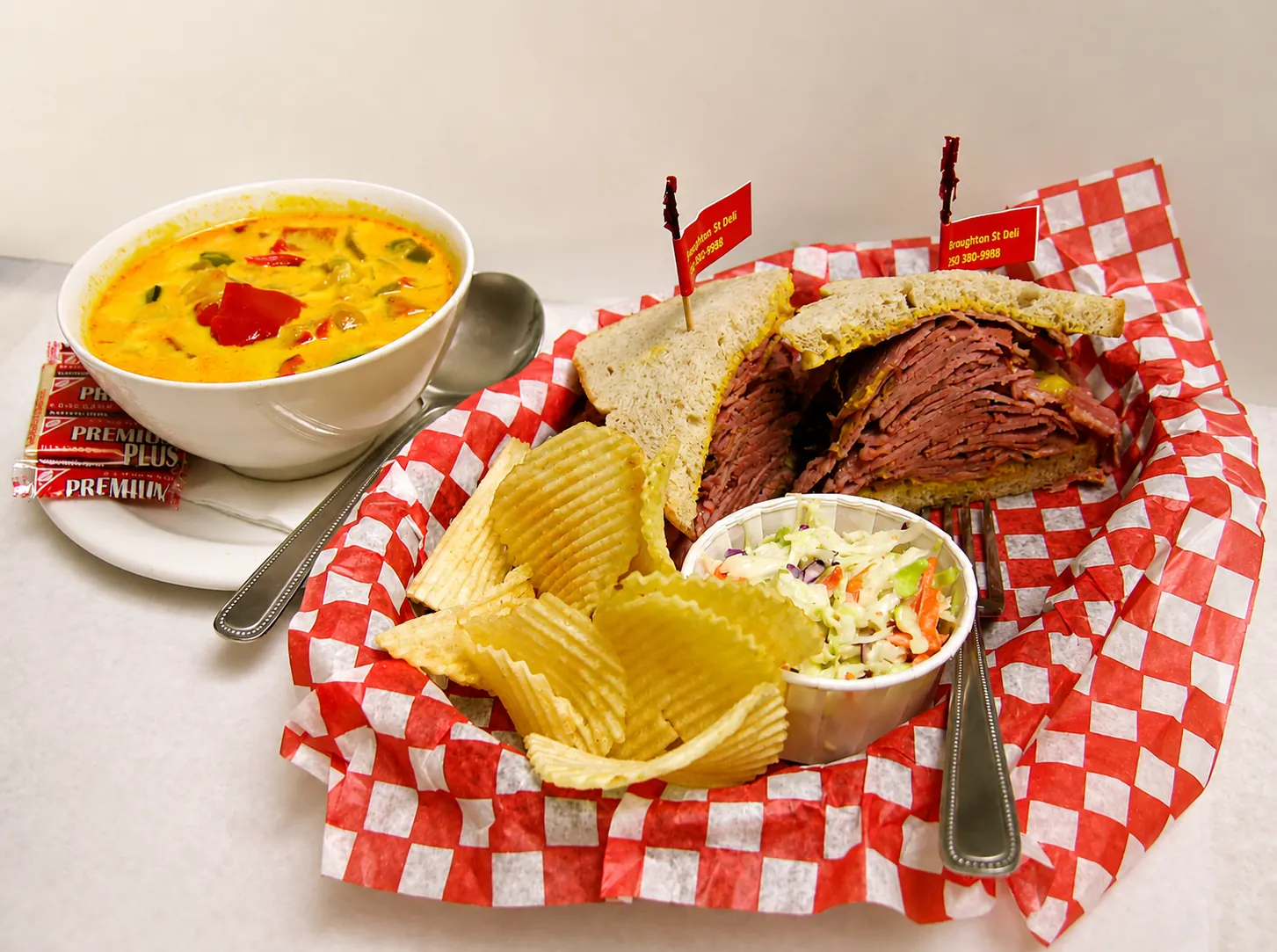 Montreal smoked meat sandwich, coleslaw and chips, with a separate bowl of soup at Broughton Street Deli